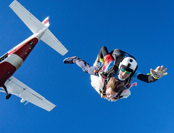 People sky diving having just jumped out of plane