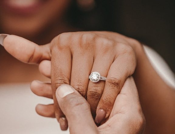Black woman's hand being held showing off engagement ring